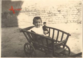 Historisches Foto Junge im Bollerwagen mit Soldatenpuppe
