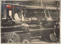 Historisches Foto In einer Fabrik, Mann an der Drehbank