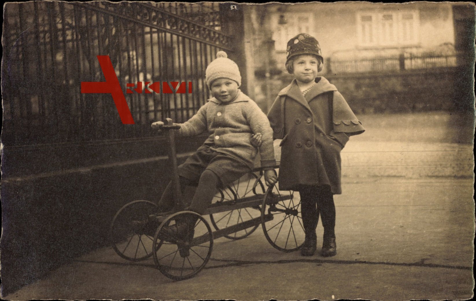 Mädchen und Junge mit einem Vierrad, Spielzeug