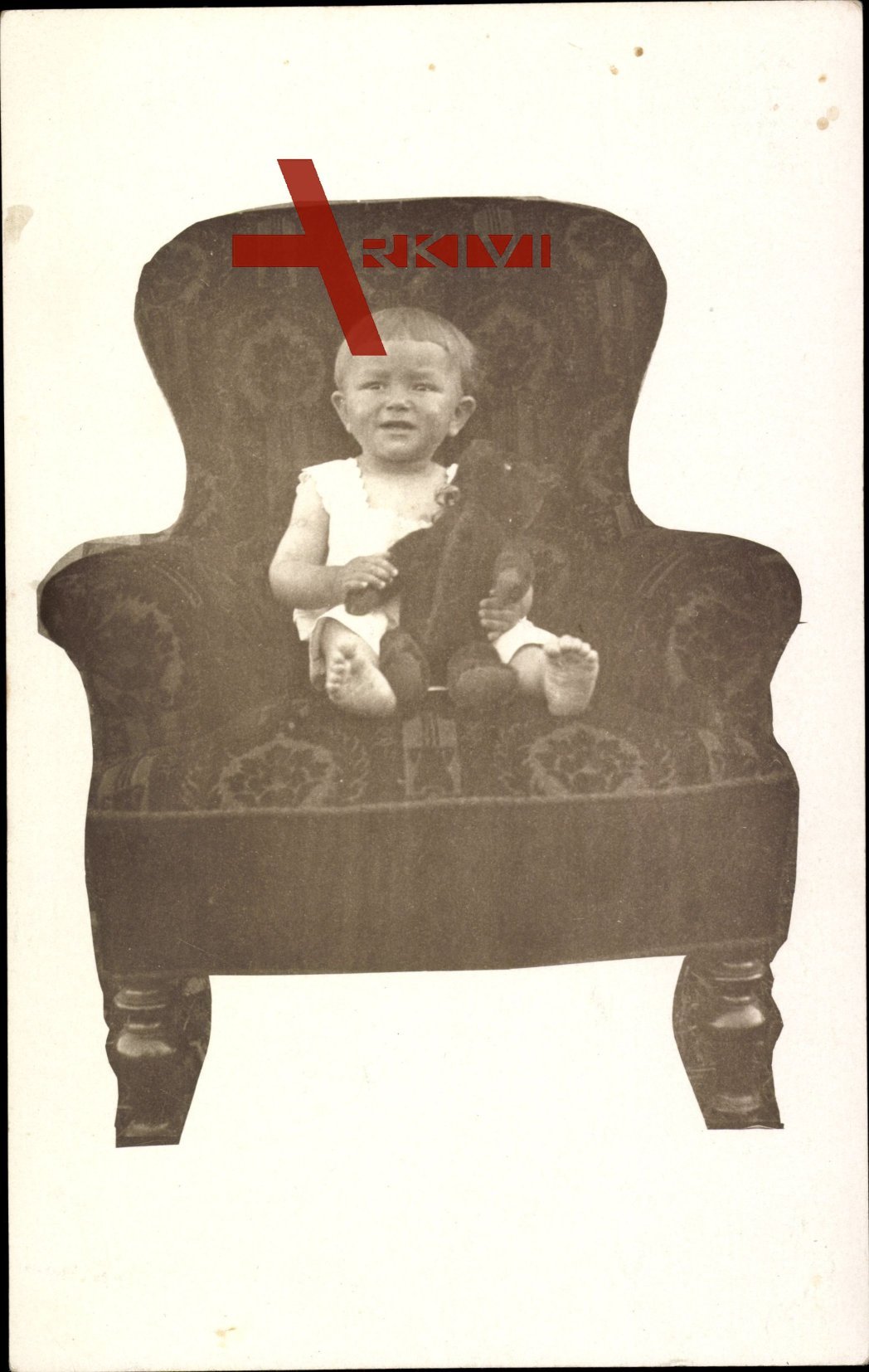 Ansicht eines kleinen Jungens auf einem Sessel mit Teddy