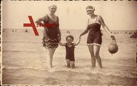 Frauen mit einem Kind am Strand, Badekleider, Spielball