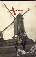 Deutscher Soldat in Uniform auf einem Pferd vor einer Windmühle