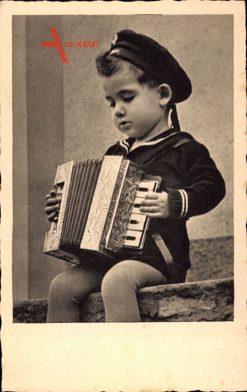 Kleiner Junge in Matrosenuniform spielt auf dem kordeon
