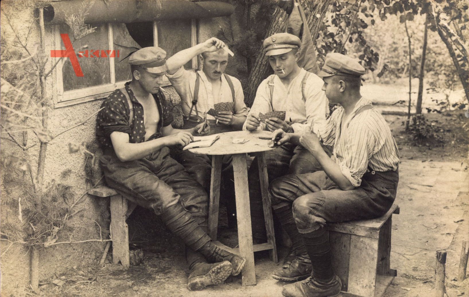 Vier junge Männer spielen Skat, Zigarette rauchend