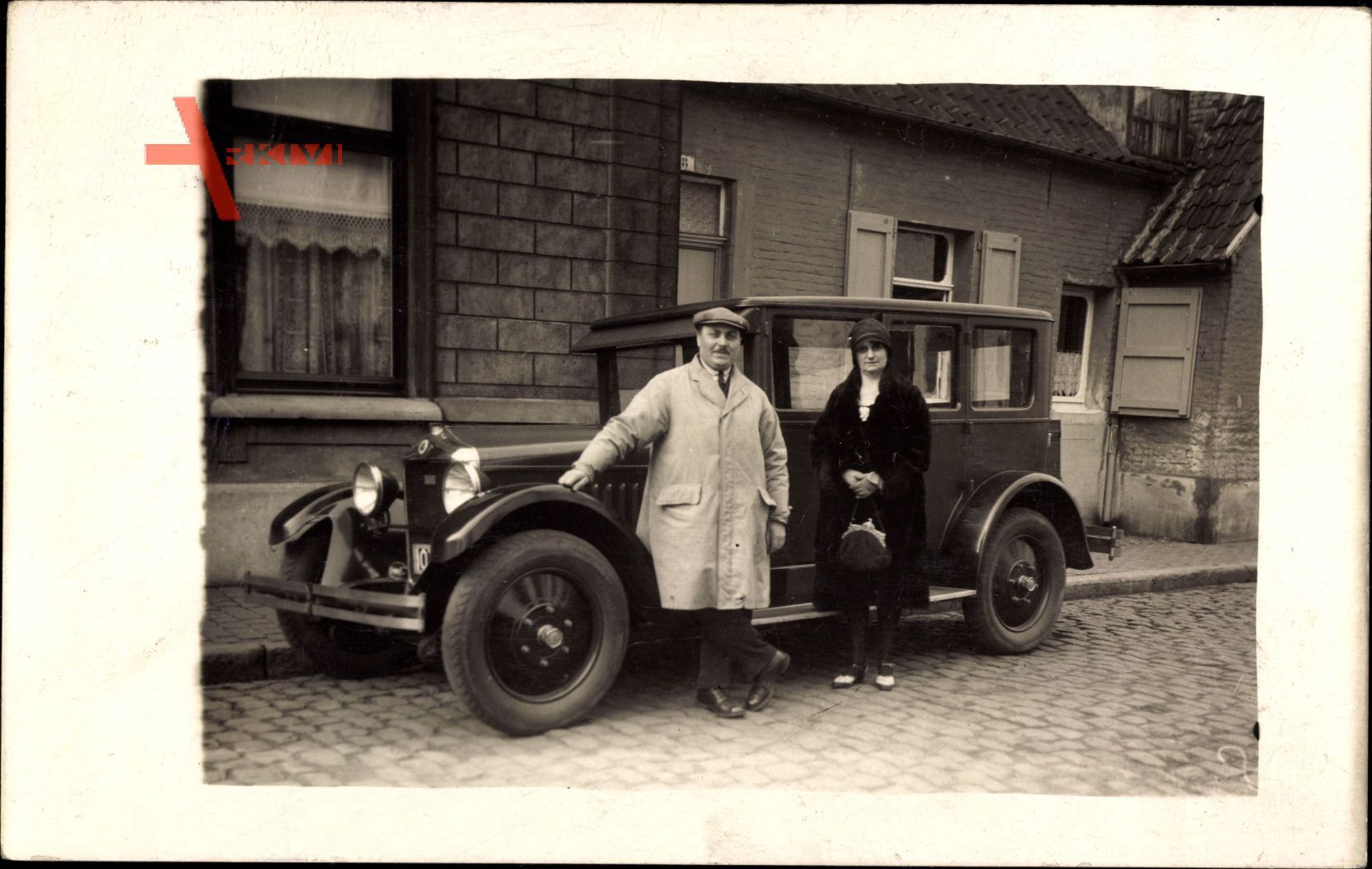 Frankreich, Mann und Frau vor einem Auto, Wohnhaus, Handtasche